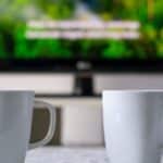 tasses a cafe avec une television et des sous titres en arriere plan
